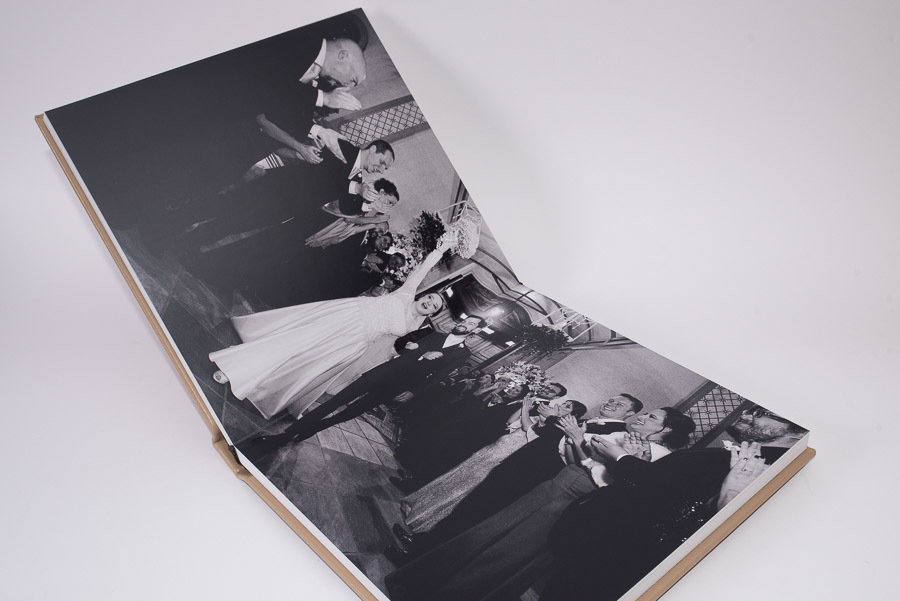 foto em preto e branco da chegada do casal no salão de festas nas paginas abertas do album de casamento sophia e alvaro sao paulo SP moema capa de couro autentico album de fotos por Clovis Augusto com a marca mundareu albuns