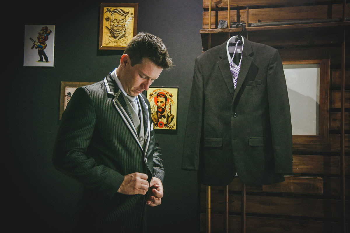 Quase tudo pronto, noivo abotoa seu terno.