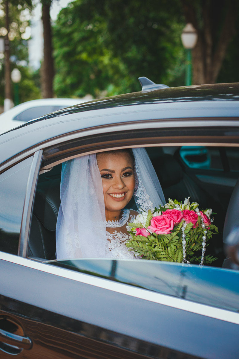a Noiva Mayara Chega em um lindo carro, muito feliz, olha o sorriso dela.