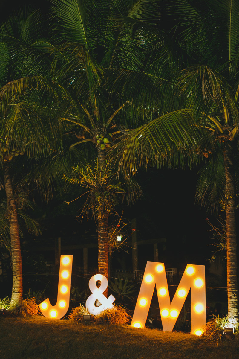 iniciais do casal, num letreiro iluminado na recepção, as margens da piscina.