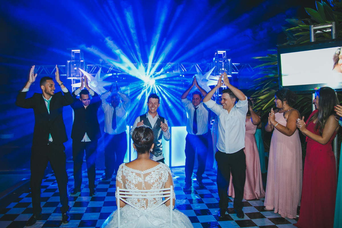 A dança continua, o noivo se exibe e os padrinhos fazem parte da festa.