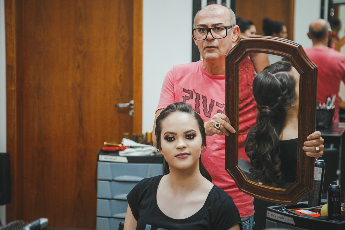 A Aniversariante olha seu cabelo pelo espelho