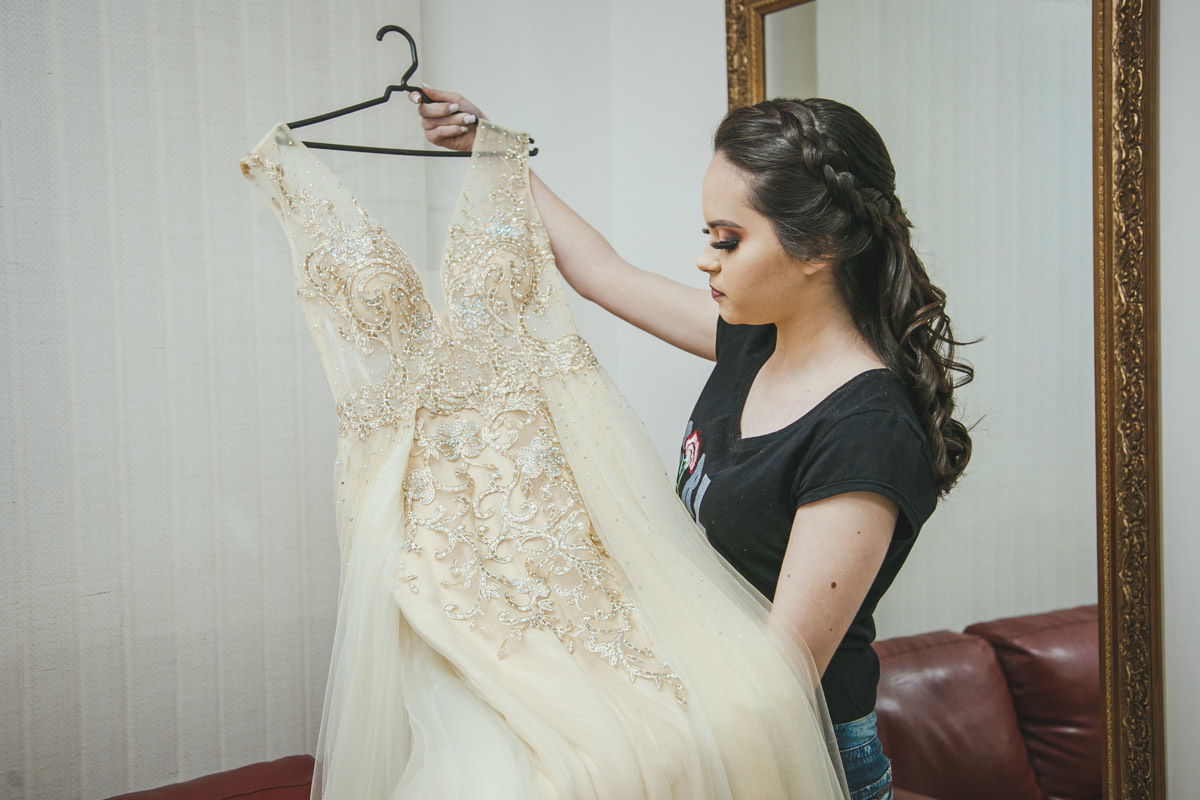 Aniversariante olha seu vestido de debutante