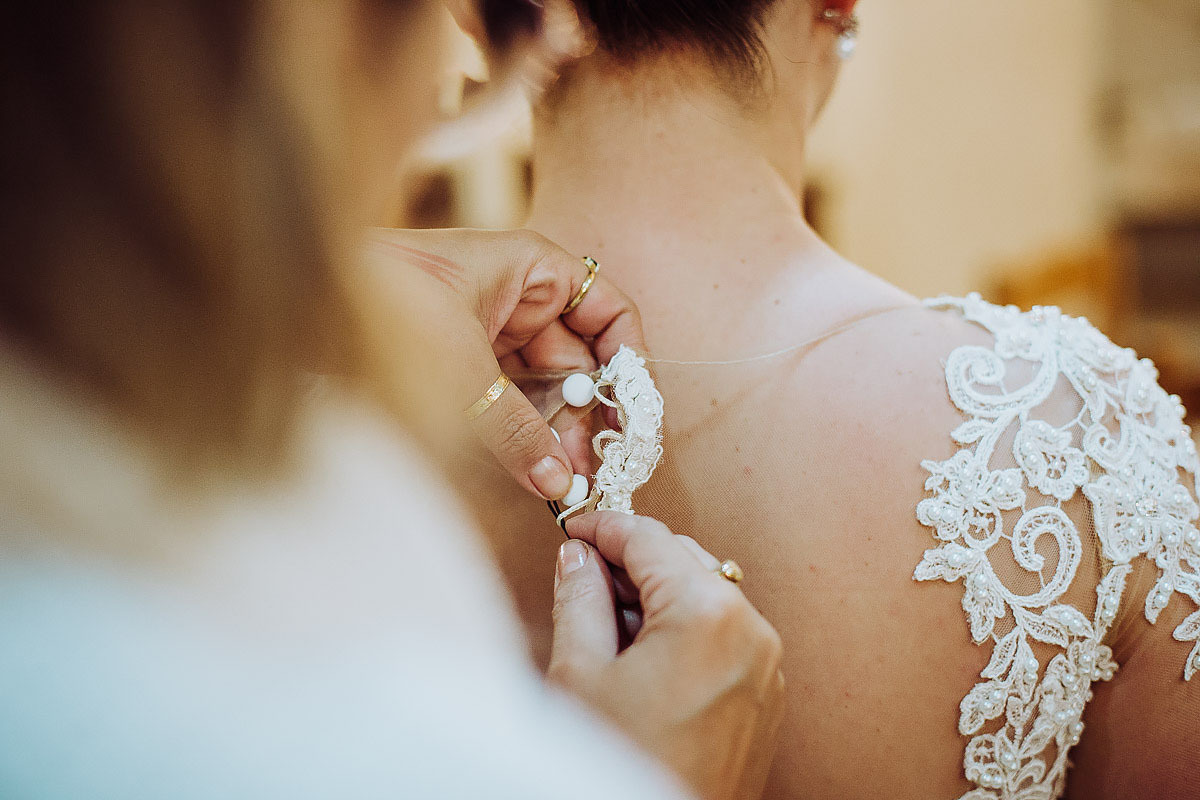 detalhes do vestido sendo abotoado
