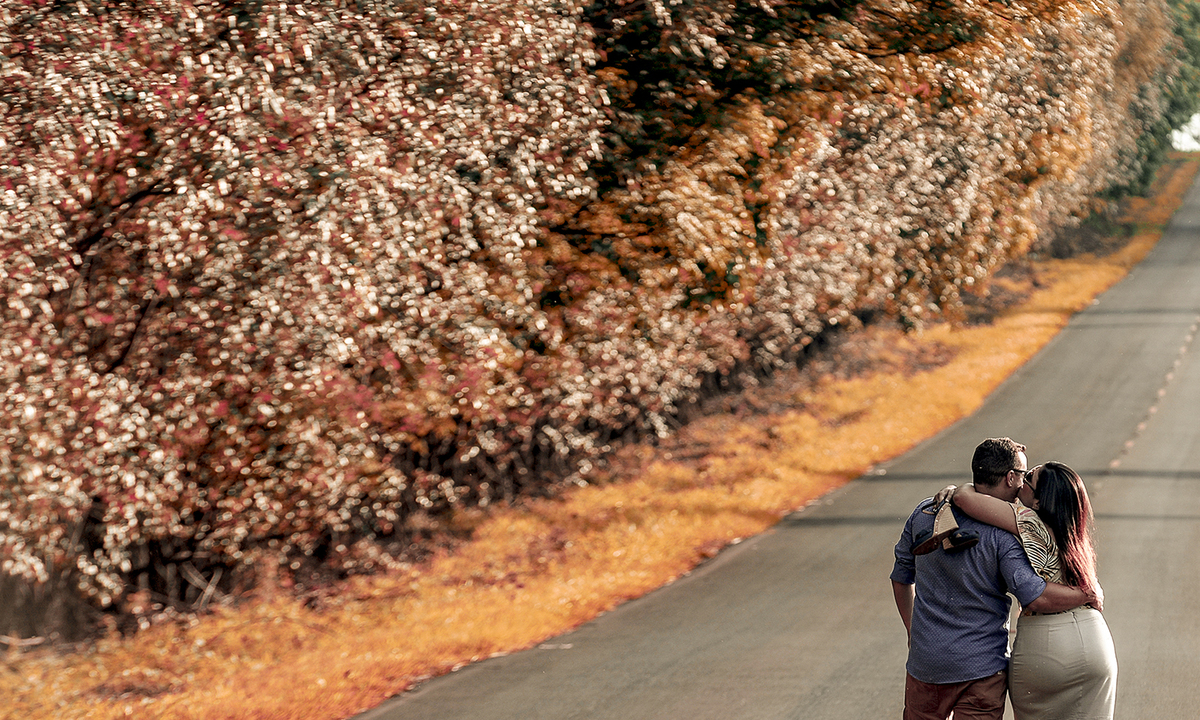Casal caminhando na estrada em sessão de pré wedding curtindo o amor foi fotografado por André Monteiro