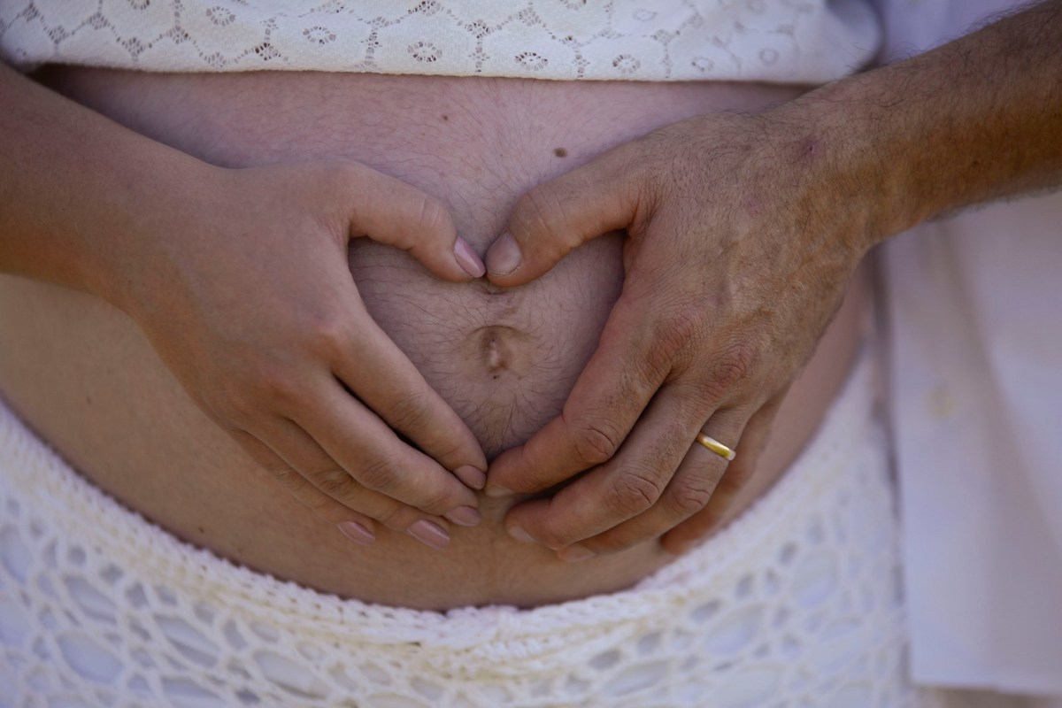 Foto de gestação tem estampado pelas mãos dos pais um coração fotografia andré monteiro