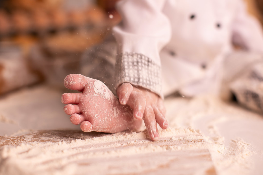 ensaio de bebe de 9 meses de padaria segurando o pezinho