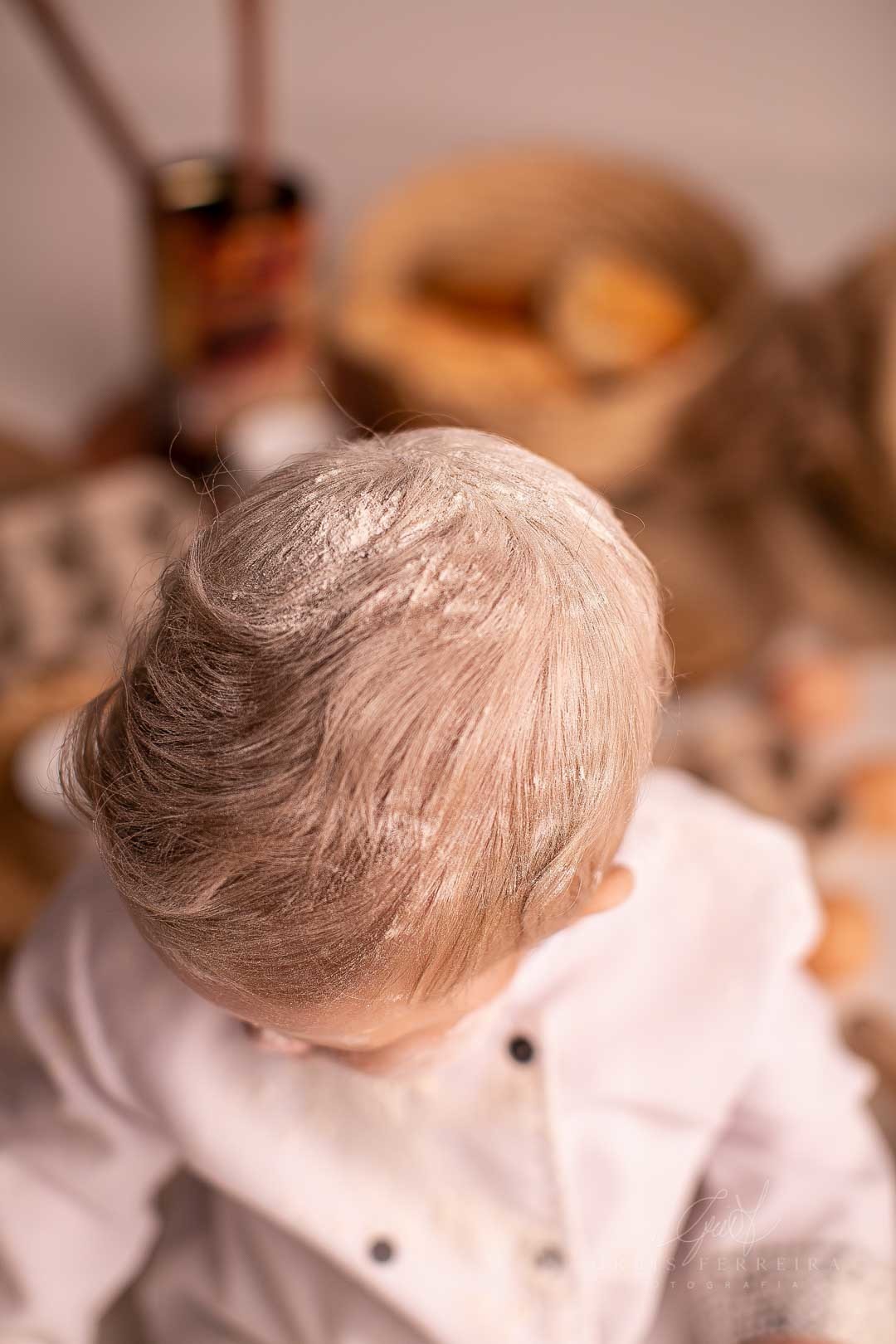 ensaio de bebe 9 meses padeiro com paes em cestos colheres de pau bule de cafe ovos e cabeca de bebe com farinha de trigo