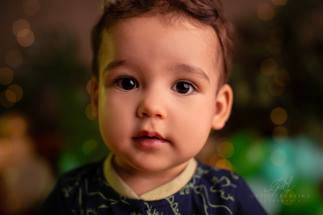 foto de retrato de bebe usando ccamisa azul e fundo desfocado