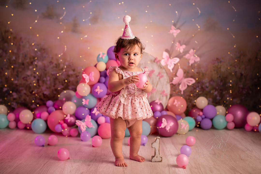 smash the cake borboleta com bebe segurando balao