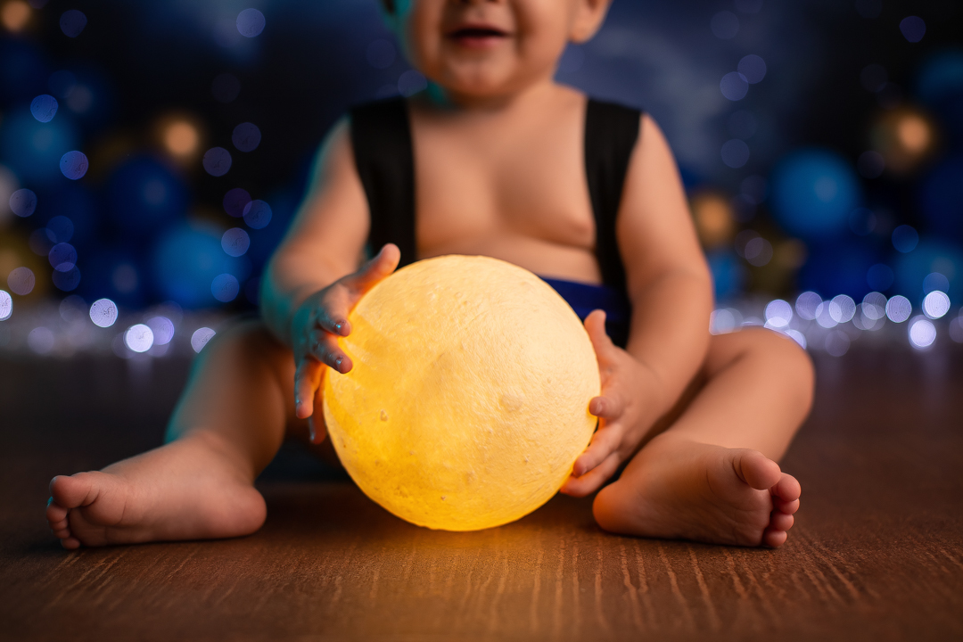 Smash the cake mickey ensaio de beb sentado atras de uma lua acesa entre as pernas com fundo azul desfocado