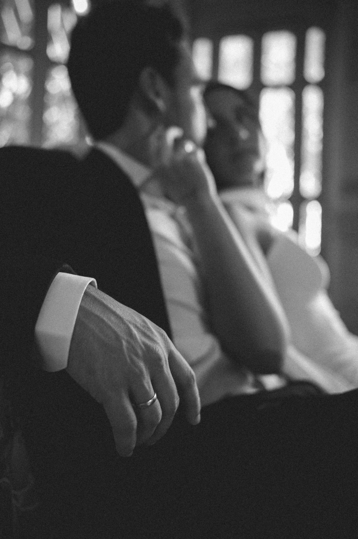 Detalhe fotográfico a preto e branco dos braços e mãos dos noivos. Registo elegante e autêntico em sessão de noivos no Rio de Janeiro.