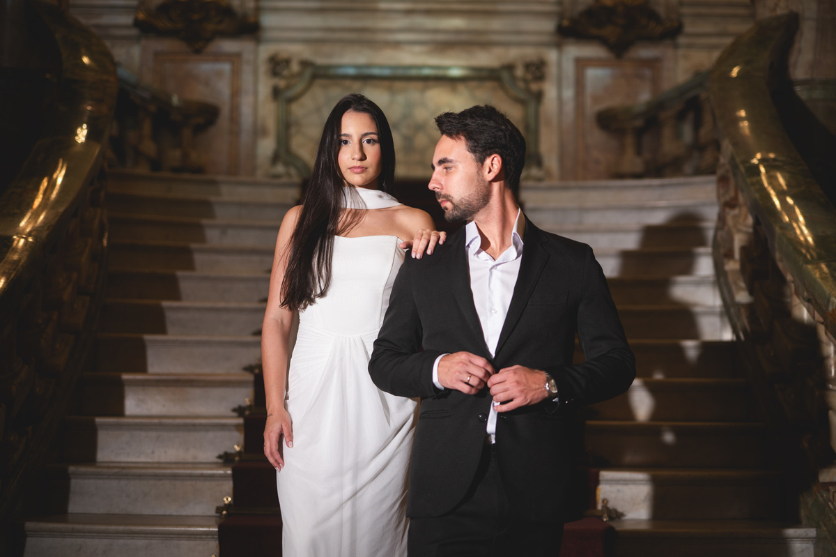 Noiva com a mão no ombro do noivo nas escadarias do Theatro Municipal, compondo um retrato de luxo com fotógrafo de casamento no Rio de Janeiro