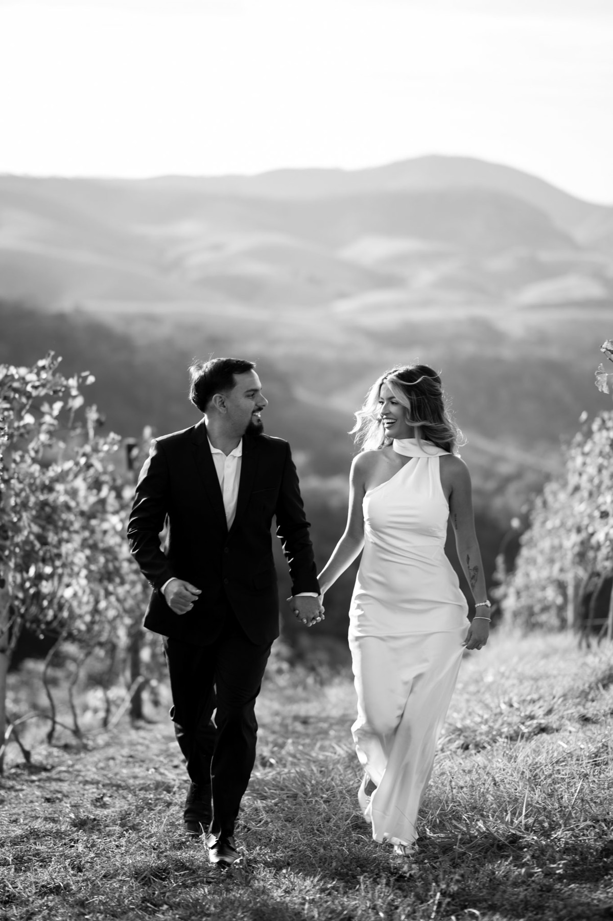 Karla e Leandro caminhando entre os vinhedos durante o ensaio pré-wedding.