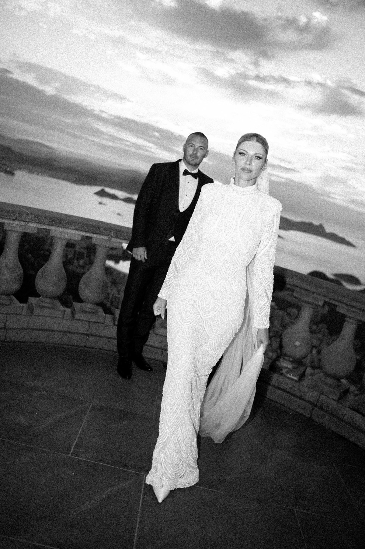 fotografia de casamento, noiva anda em direção ao fotografo enquanto noivo a observa após cerimonia de casamento no cristo