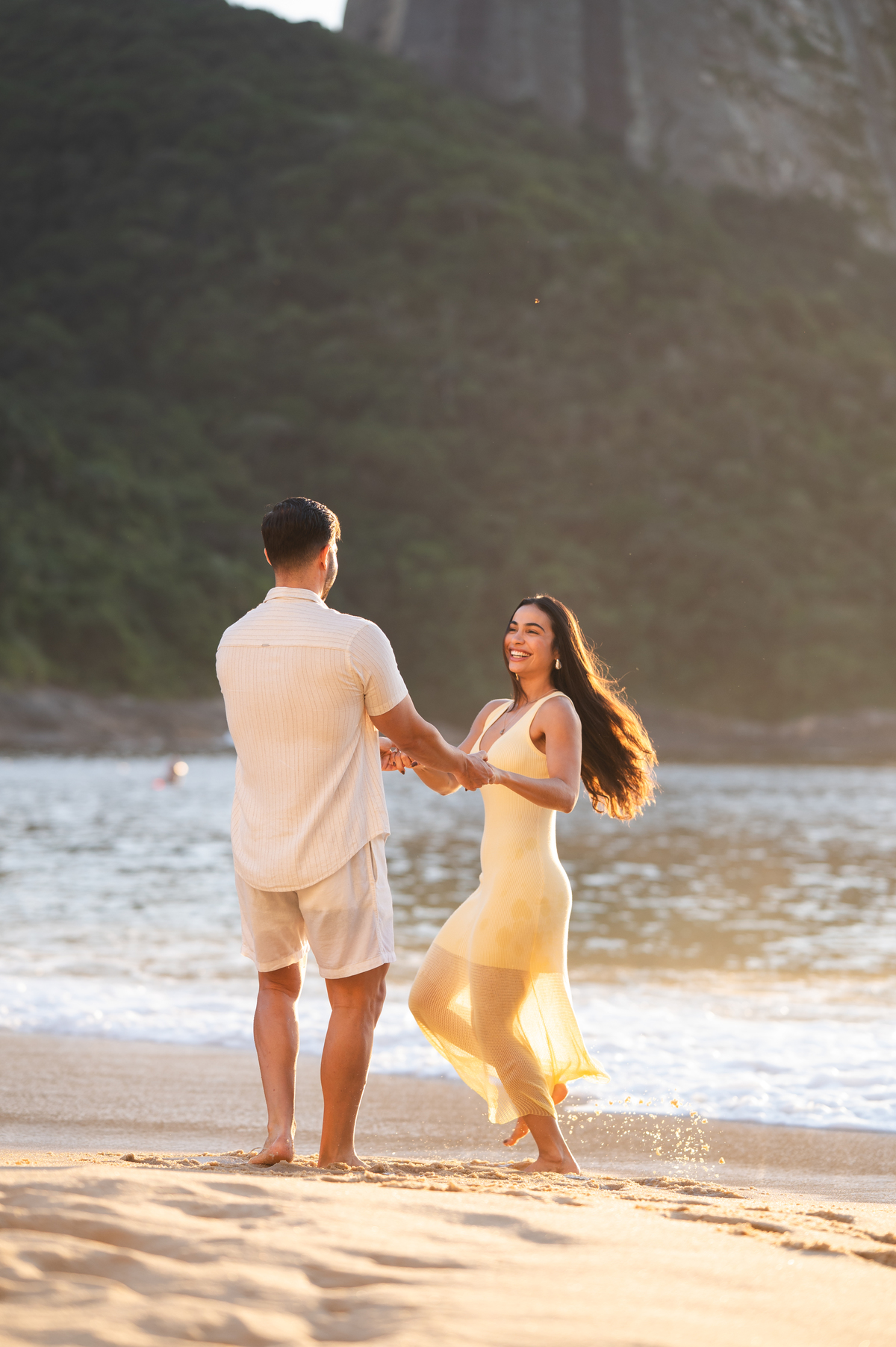 casal gira feliz durante ensaio pre wedding na praia vermelha com fotografo douglas felicio