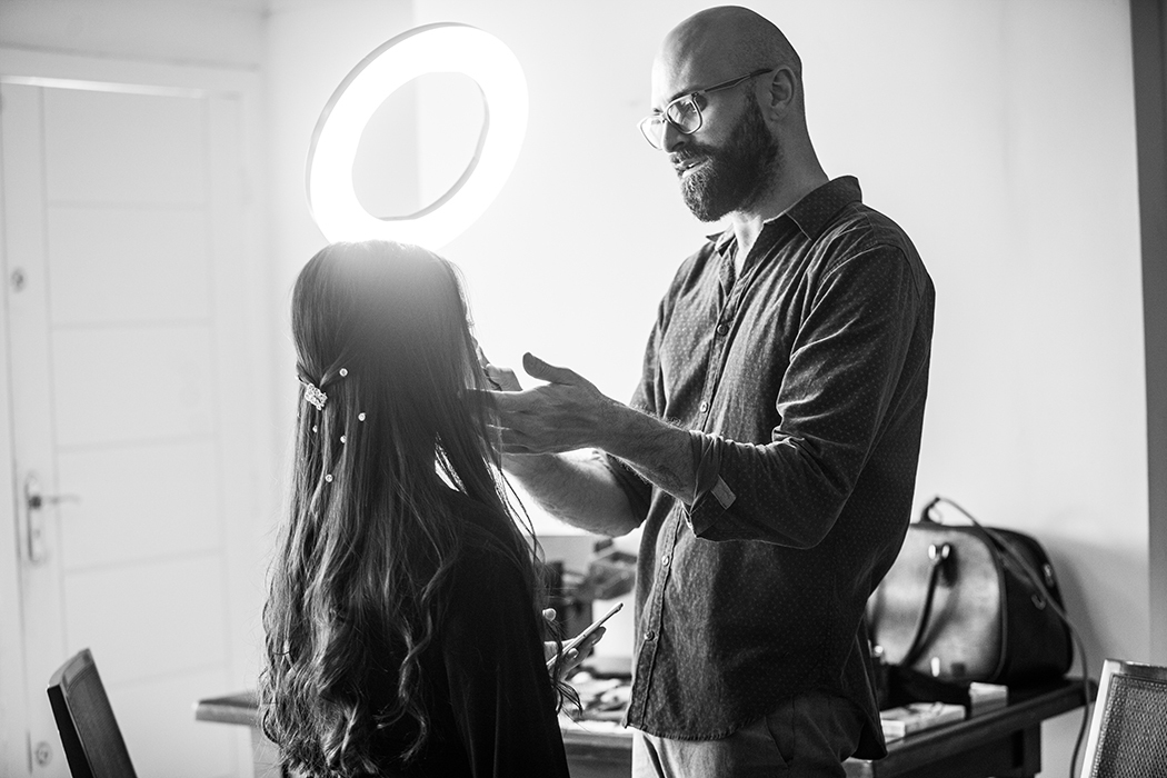 maquiador conferindo makeup de jovem em fotografia em preto e branco
