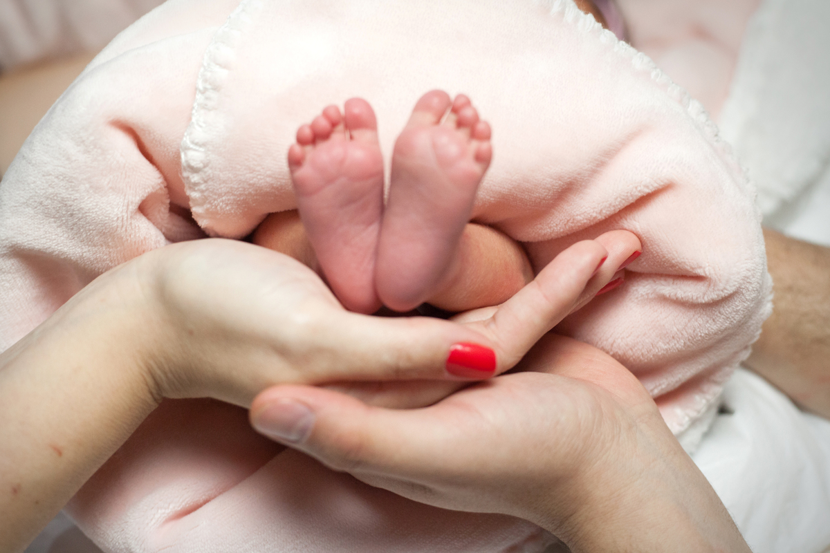mãos segurando os pezinhos do bebê