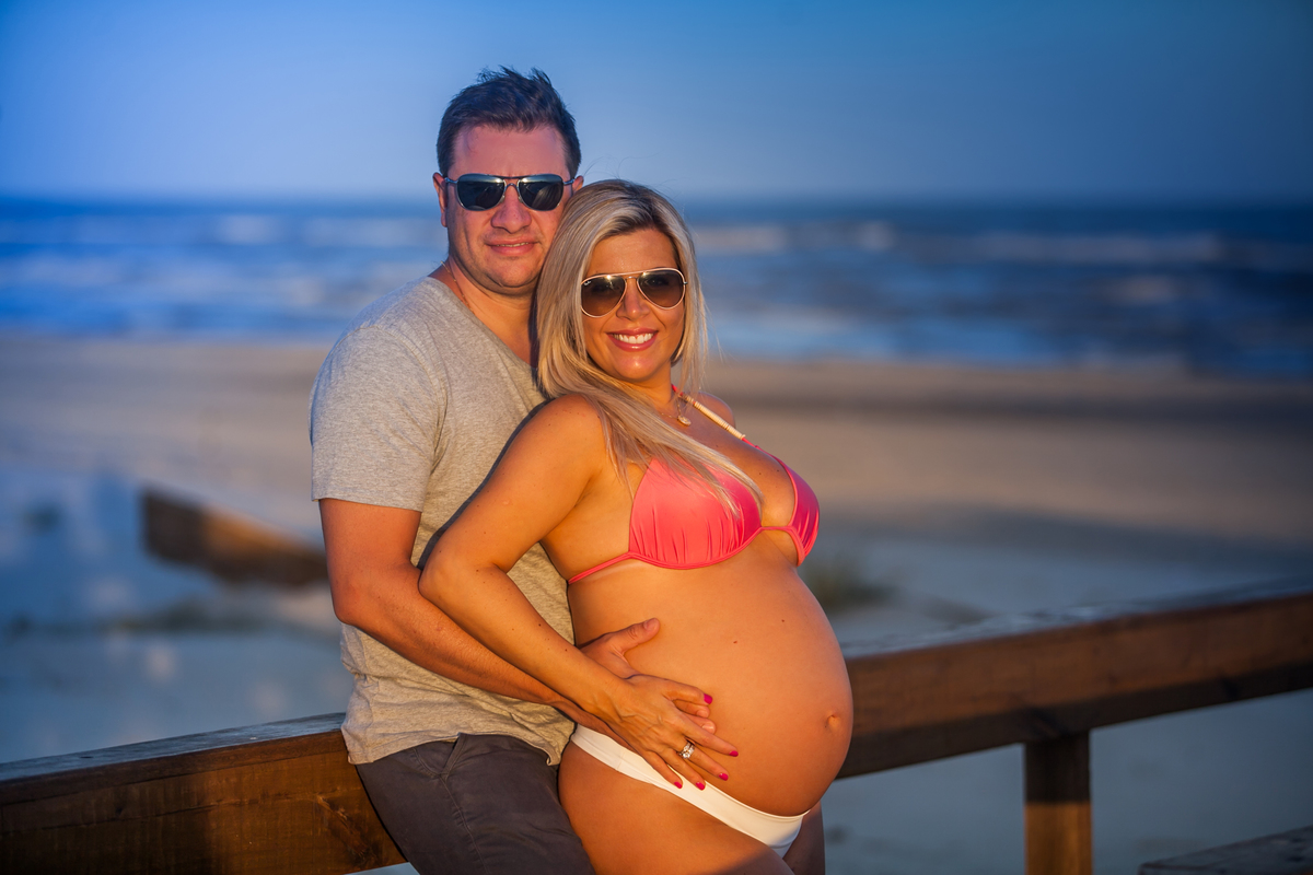 gestante de biquini com o marido na beira da praia