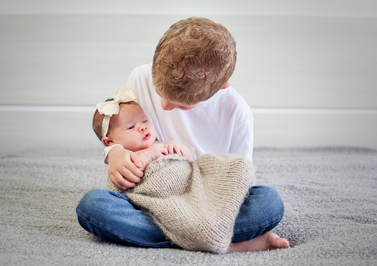 menino segurando bebê
