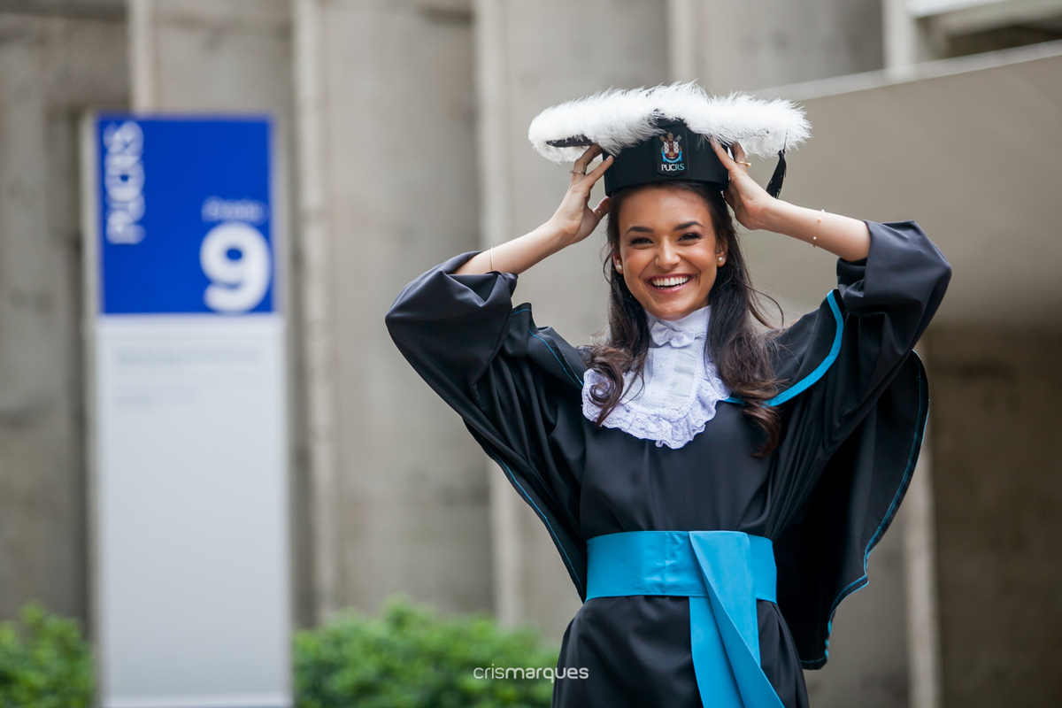 Formanda em frente a faculdade de arquitetura da PUC RS 