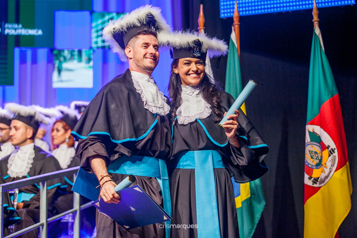 formanda de arquitetura posando para foto com o melhor amigo em frente às bandeiras  