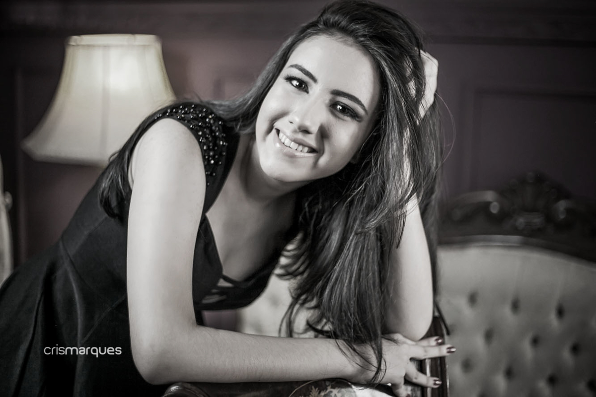 menina apoiada em cadeira e com mão no cabelo