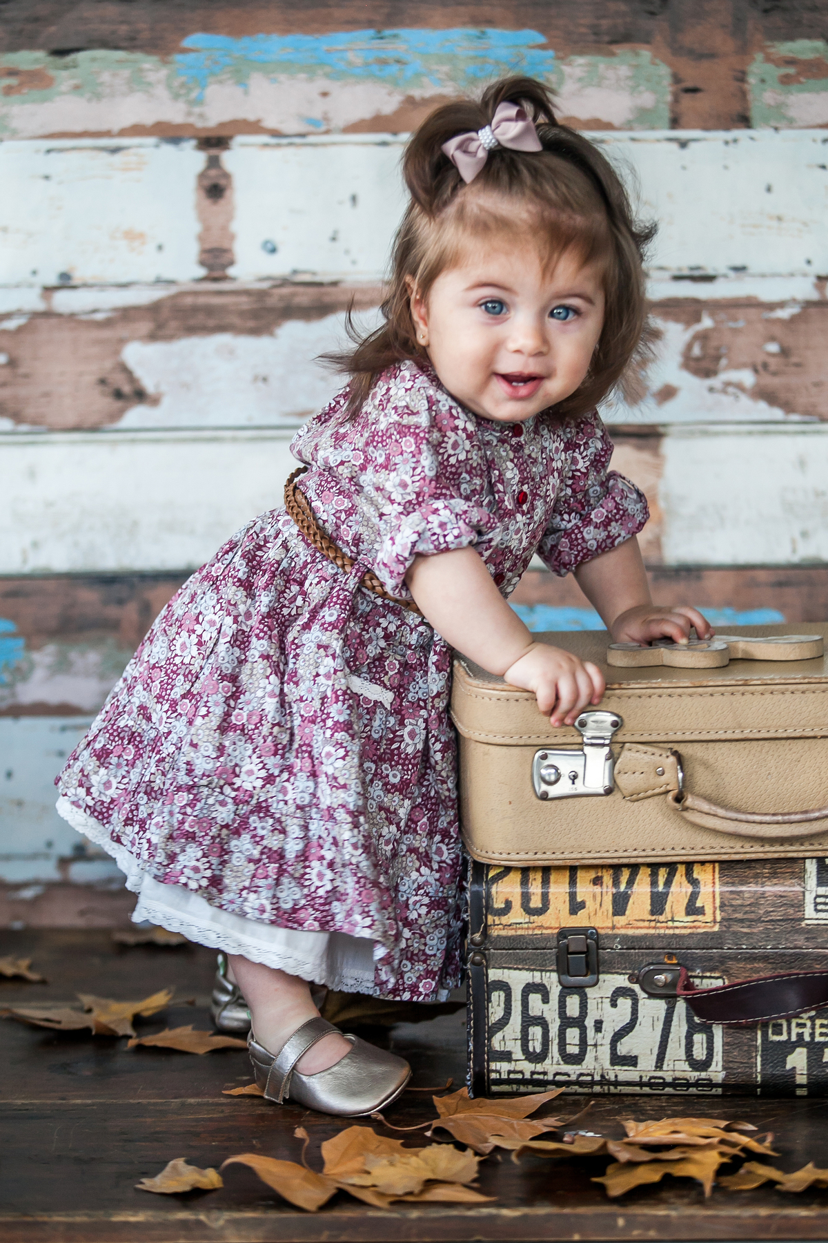 bebê apoiada em maletas