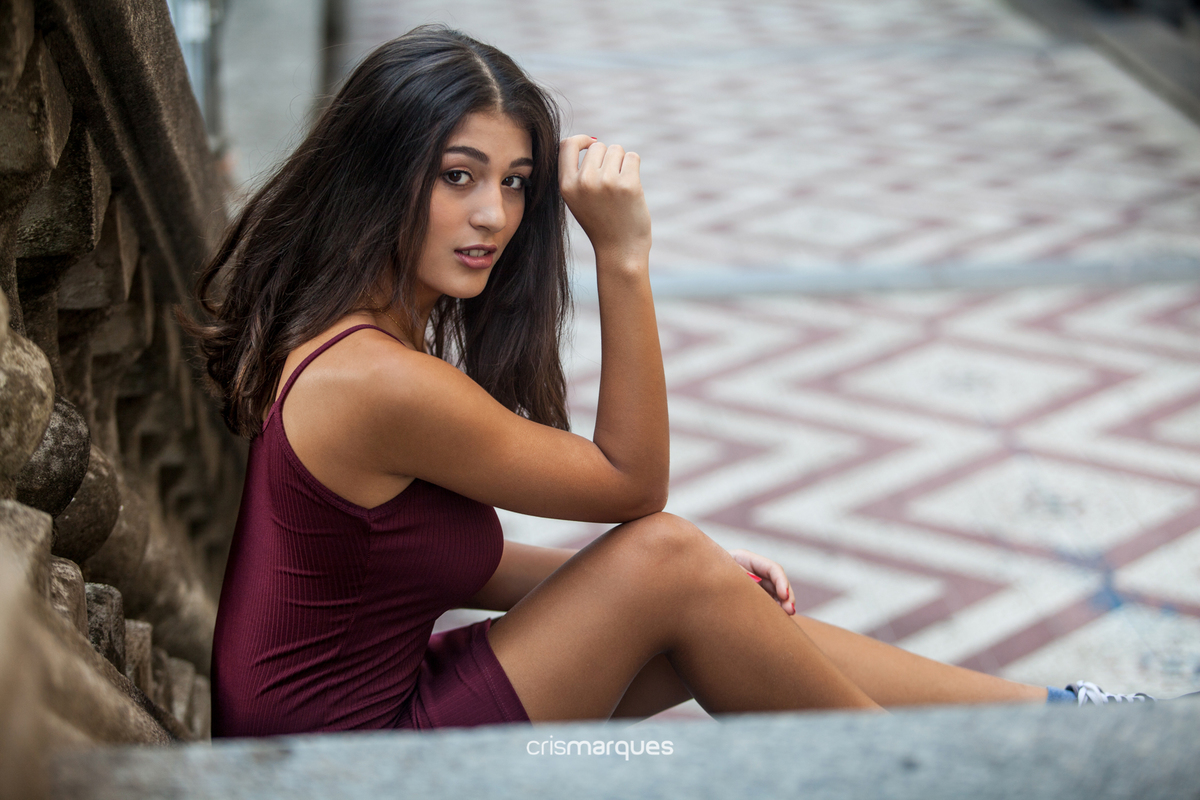 Jovem usando vestido bordô na escadaria da Borges de Medeiros