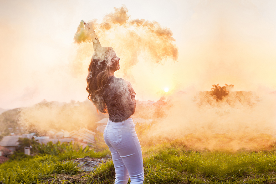 menina com bastão de fumaça colorida amarela