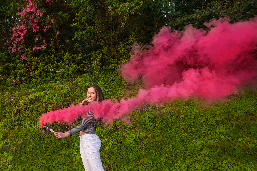 menina segurando bastão de fumaça rosa