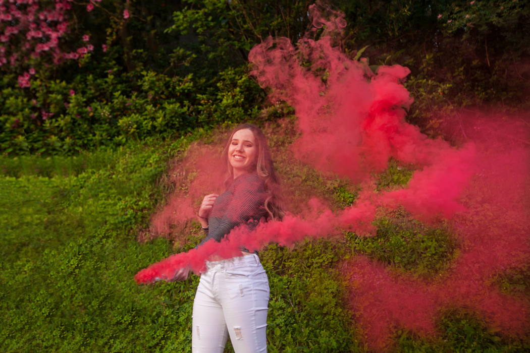 menina em meio a fumaça de bastão rosa 
