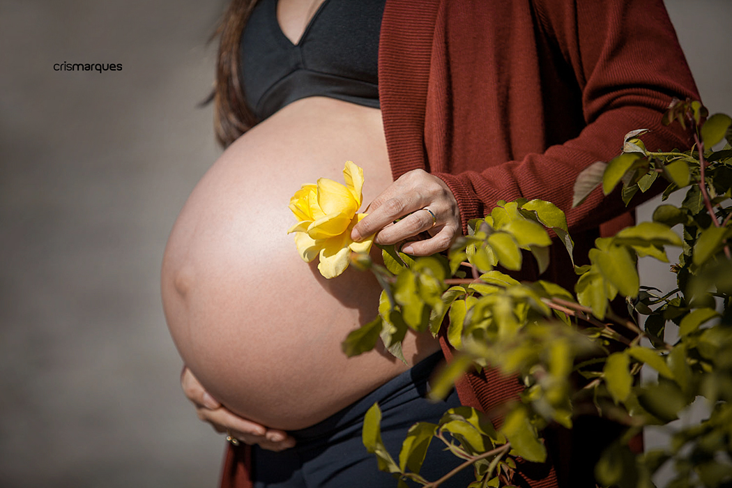gestante segurando rosa amarela junto a barriga