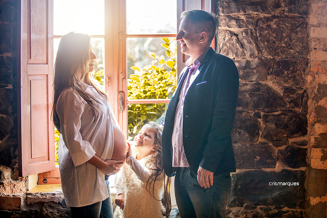 gestante e família em foto contra-luz em janela