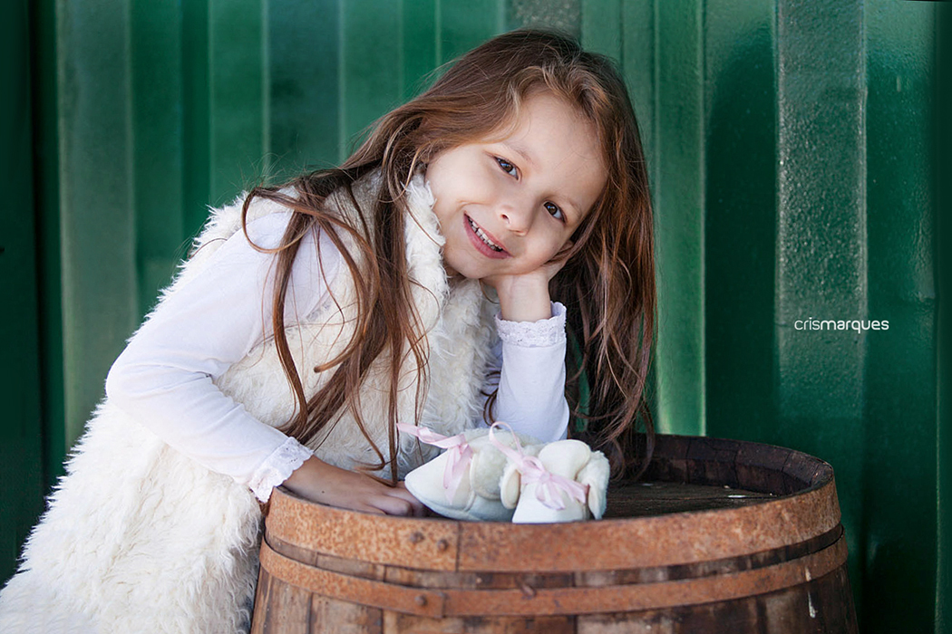 menina com o braço apoiado em barril
