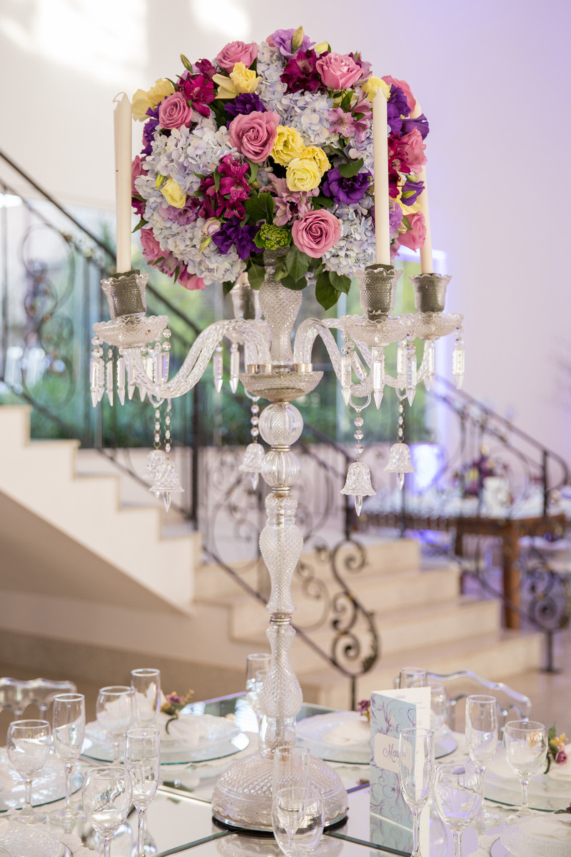 Arranjo alto centro de mesa dos convidados do casamento com flores e castiçais