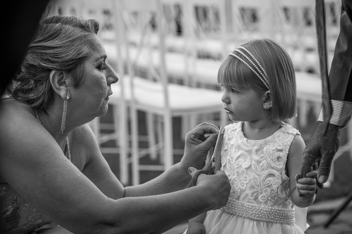 Avó ajeitando o vestido da daminha antes da cerimônia do casamento começar