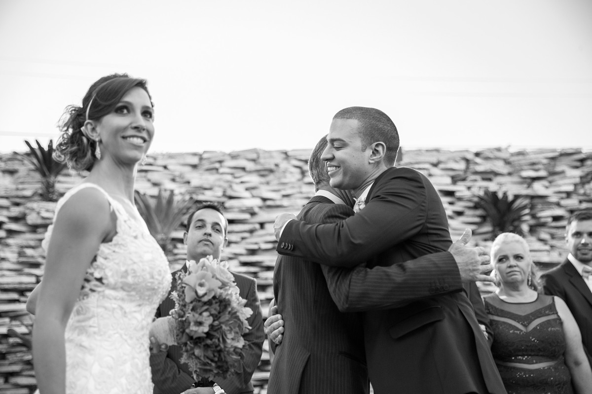 Noivo abraçando o pai da noiva na cerimônia de casamento