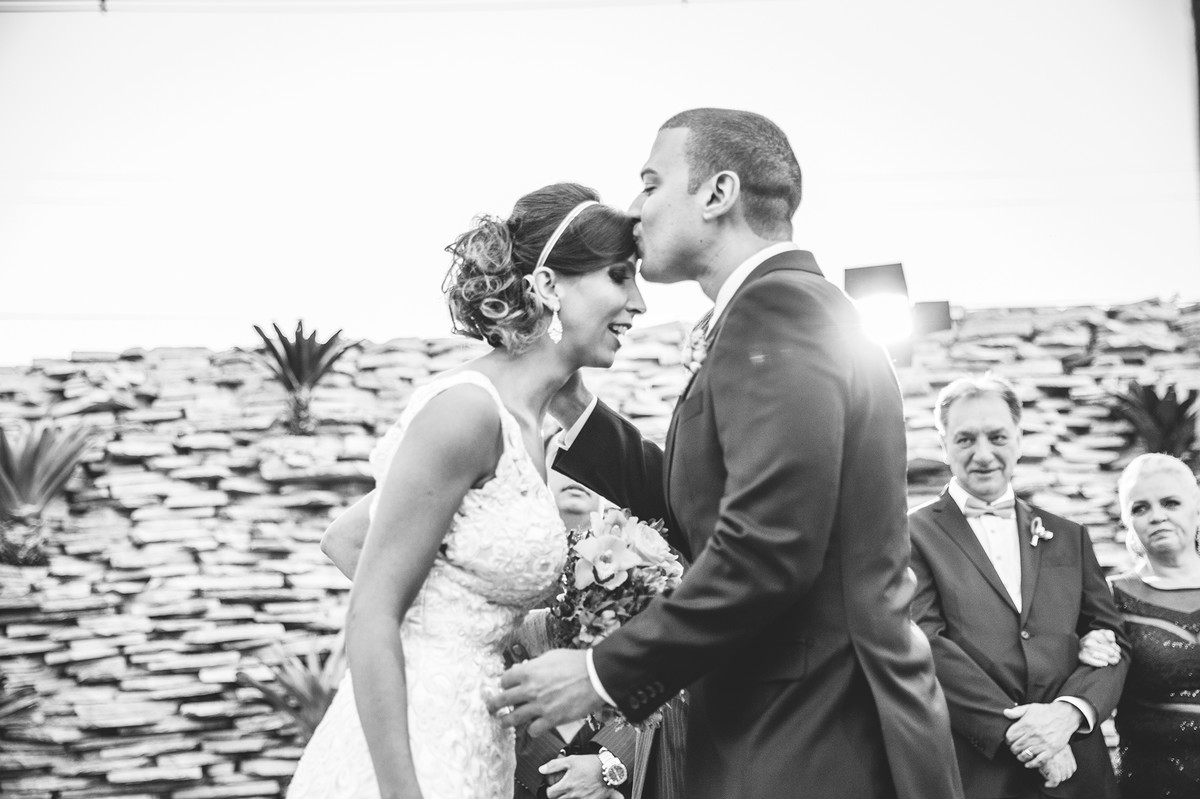 Noivo beijando a testa da noiva na cerimônia de casamento