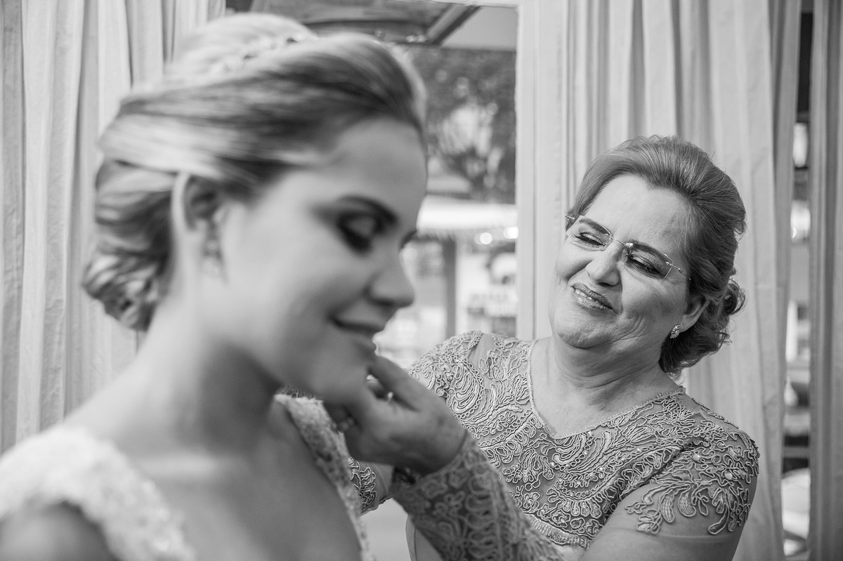 Mãe colocando o brinco na noiva no making of