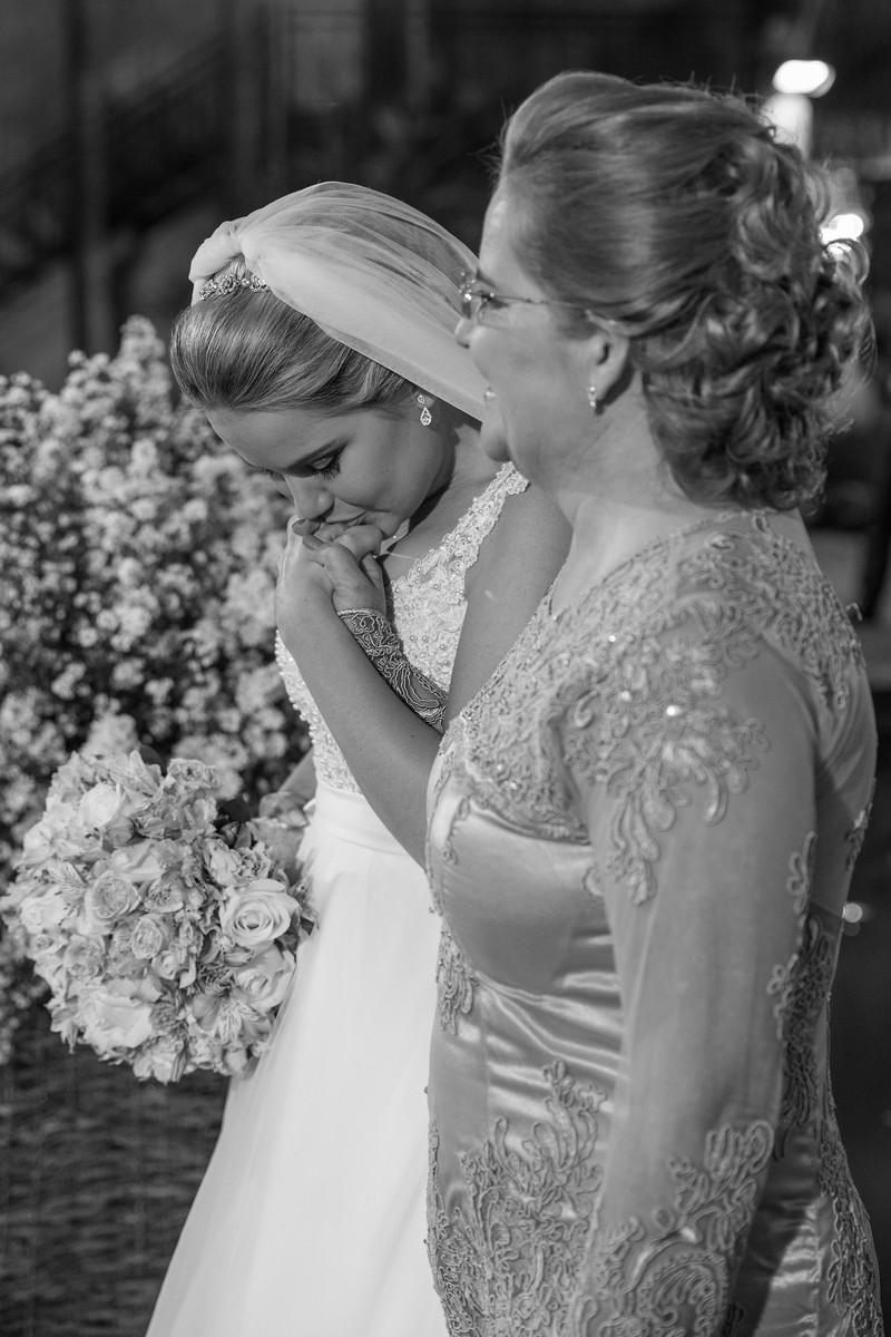 Noiva beijando a mão da mãe na cerimônia do casamento