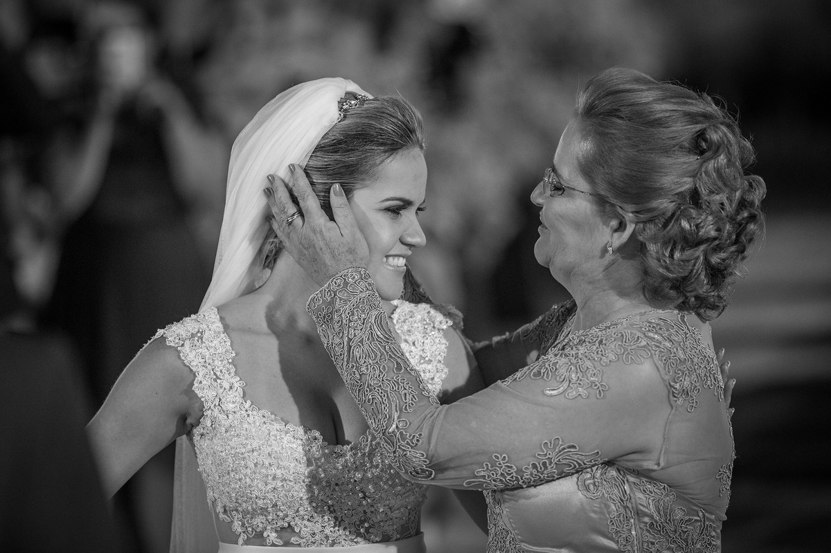 Mãe fazendo carinho no rosto da noiva na cerimônia do casamento