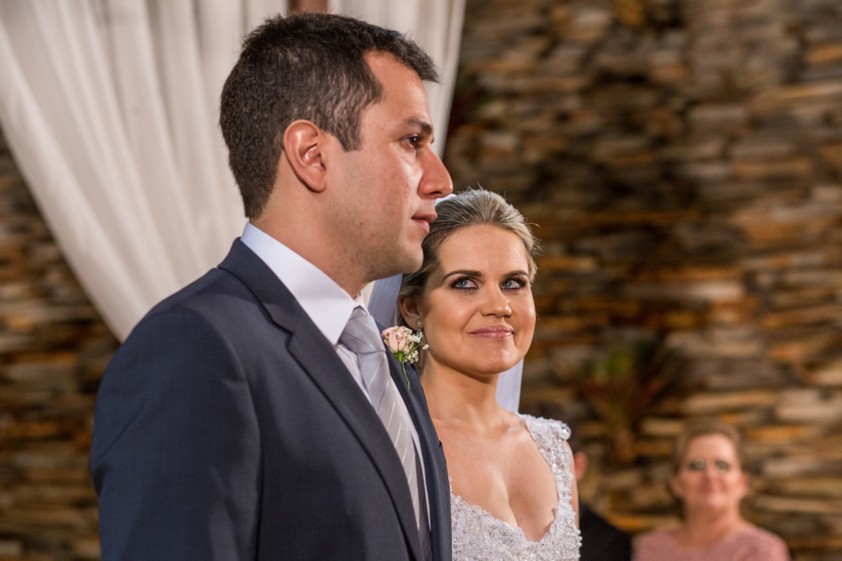 Noiva olhando para o noivo e sorrindo na cerimônia do casamento