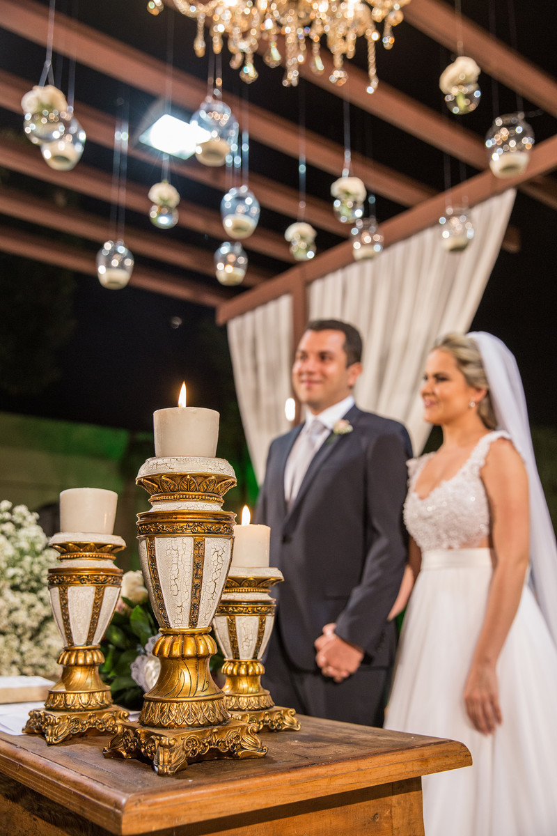 Decoração da cerimônia do casamento com velas e noivos atrás