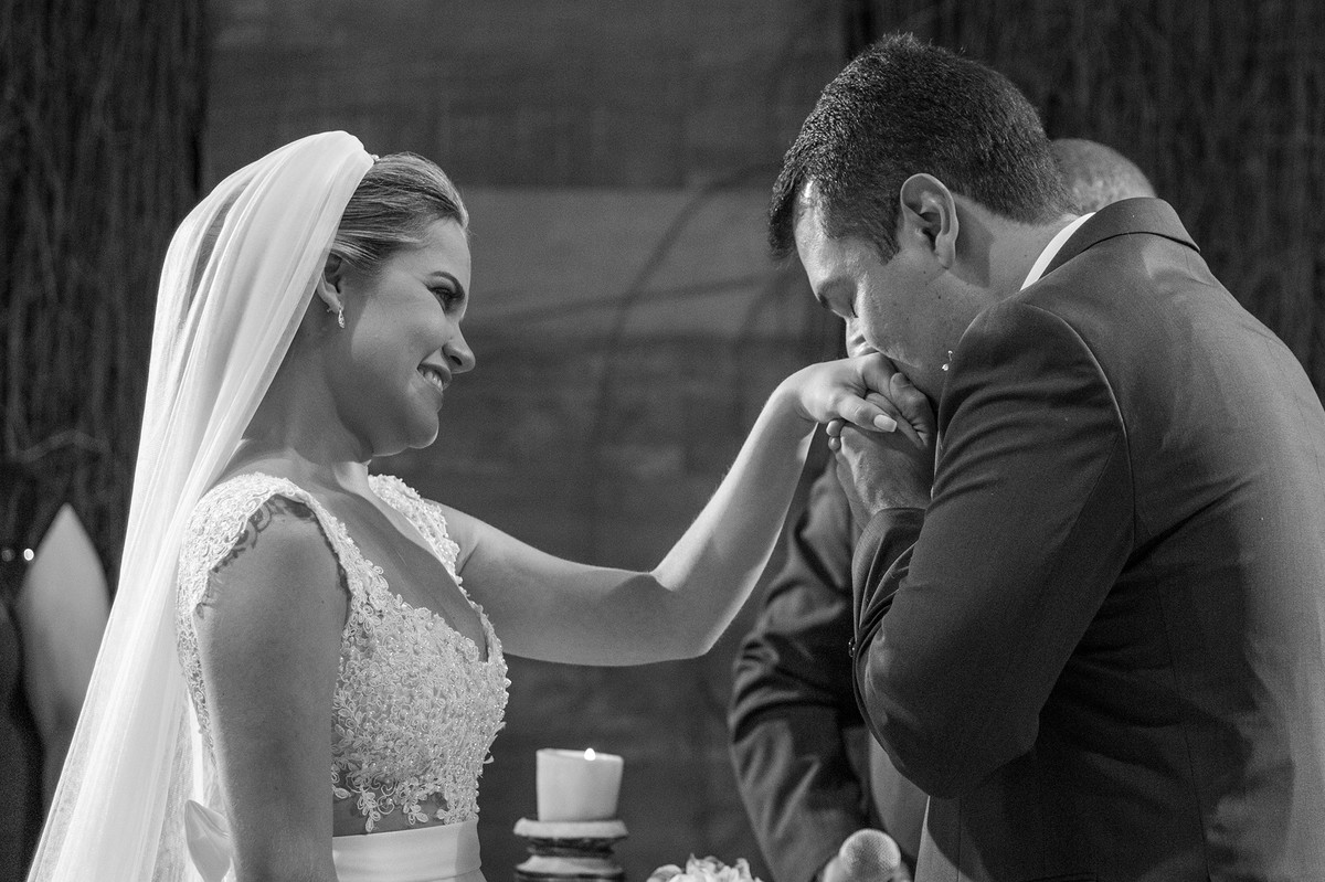 Noivo beijando a mão da noiva na cerimônia do casamento