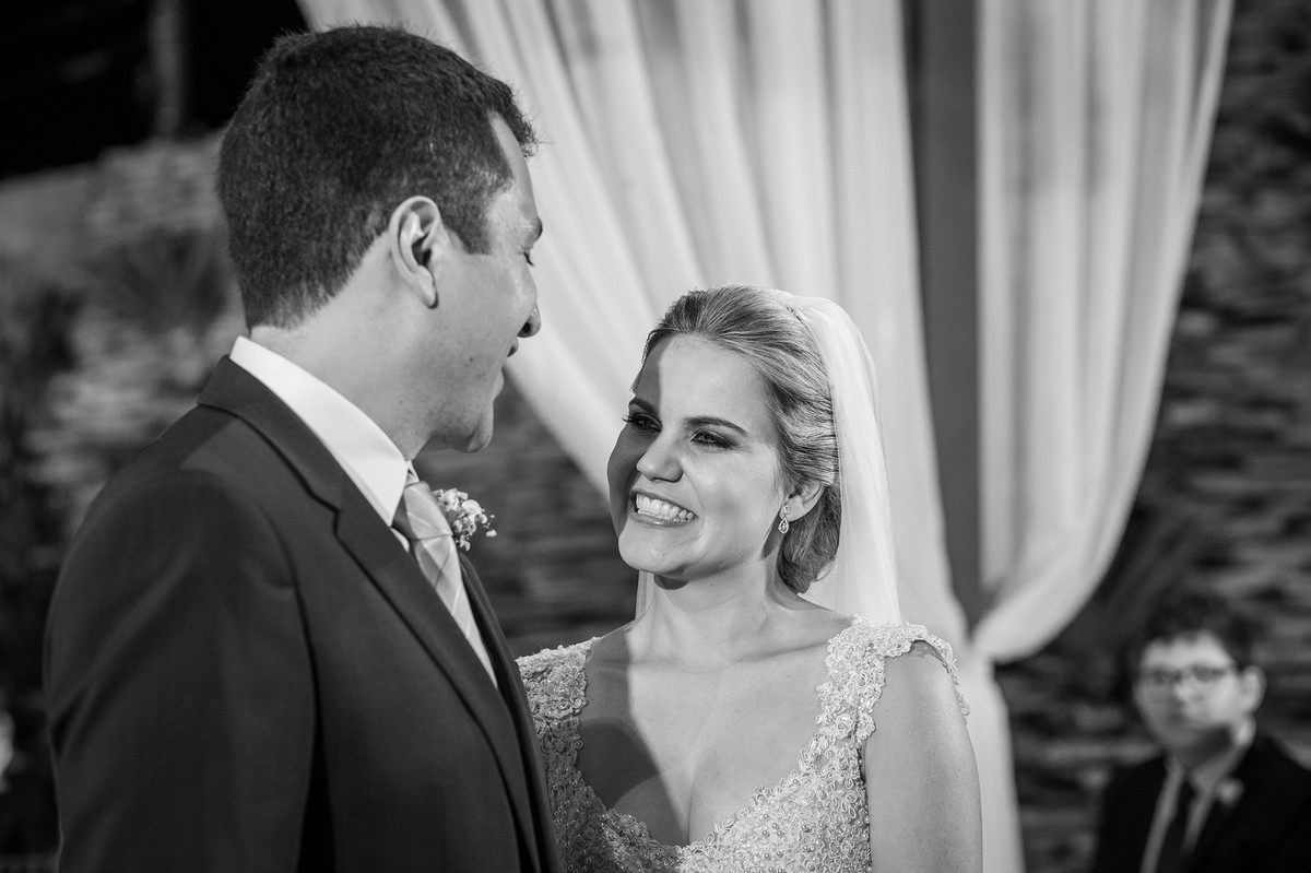 Noiva sorrindo para o noivo na cerimônia do casamento