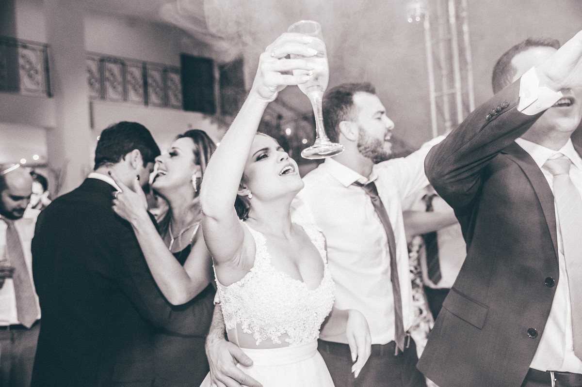 Noiva dançando bebendo champanhe na recepção do casamento