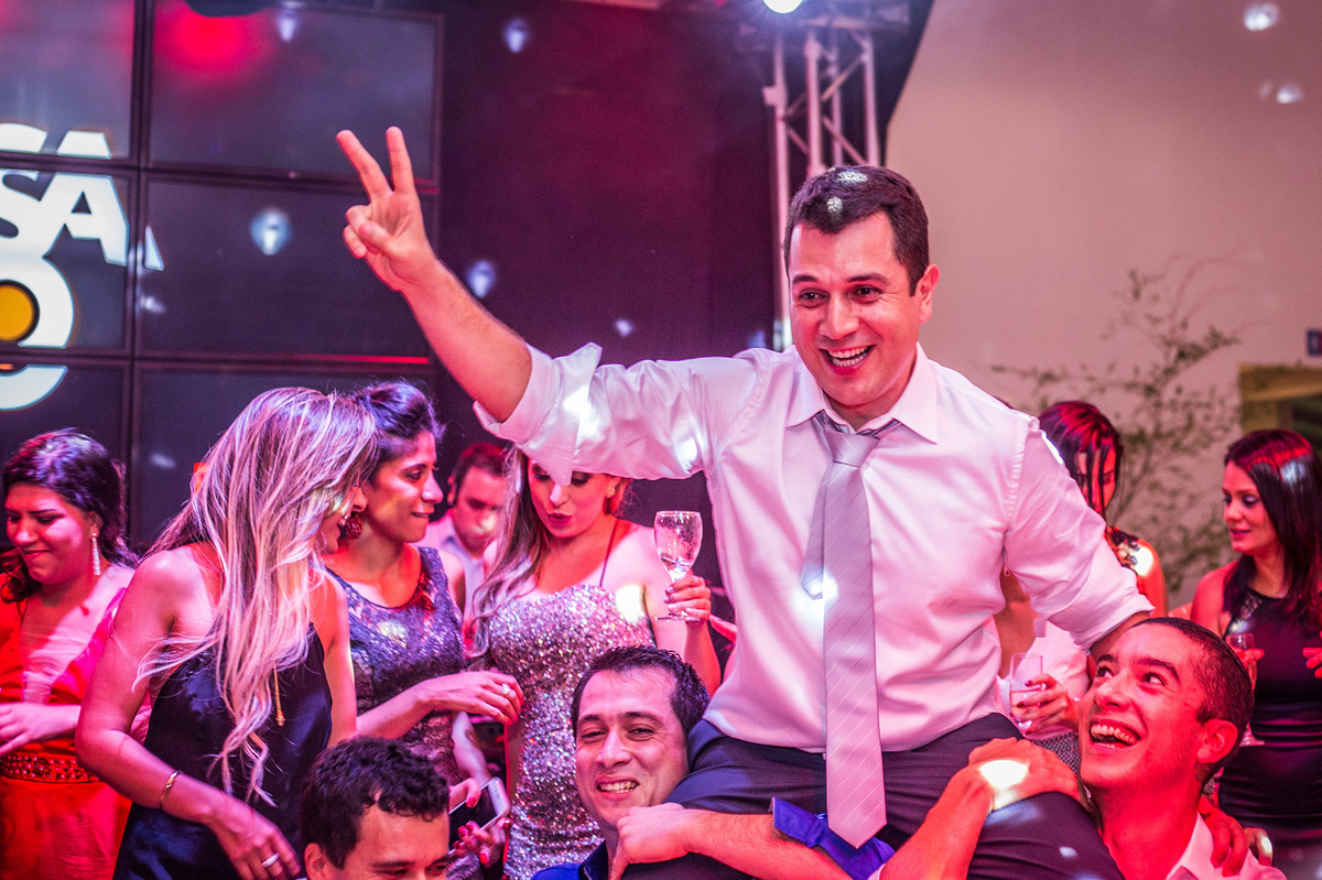 Amigos levantando o noivo na recepção do casamento