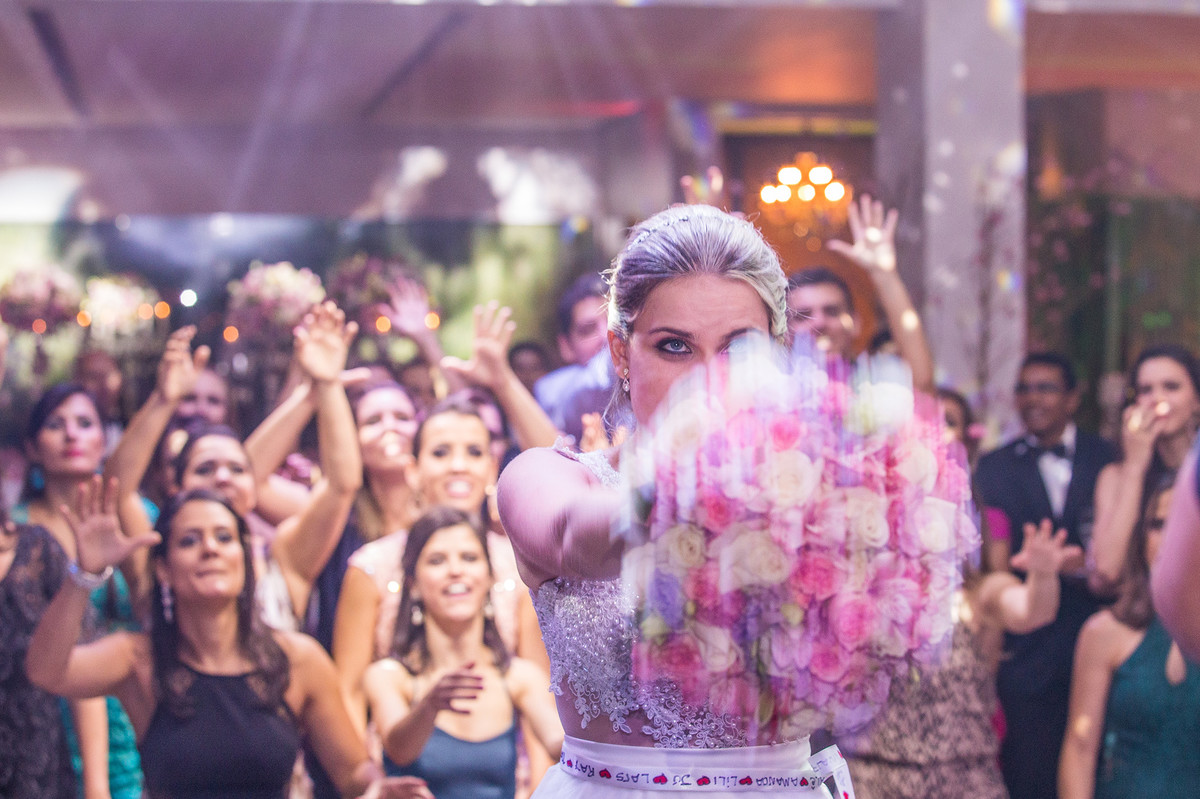 Noiva jogando o buquê na recepção do casamento