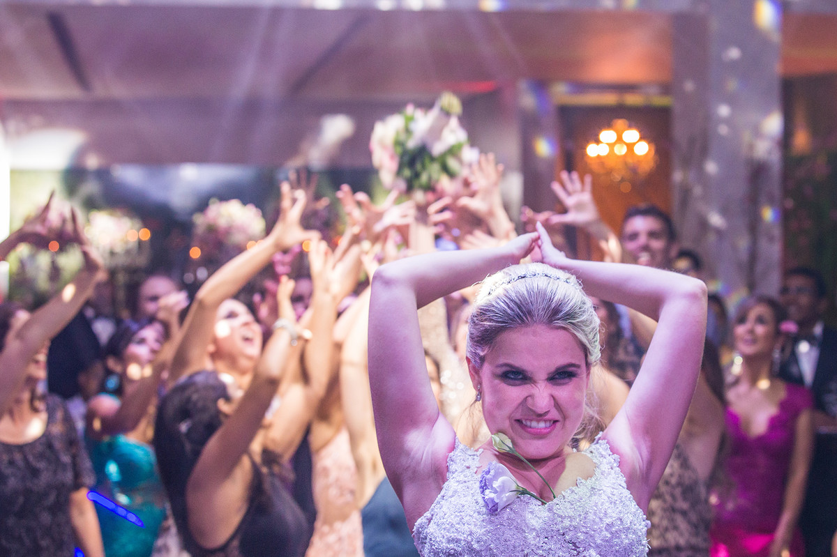 Noiva jogando o buquê na recepção do casamento